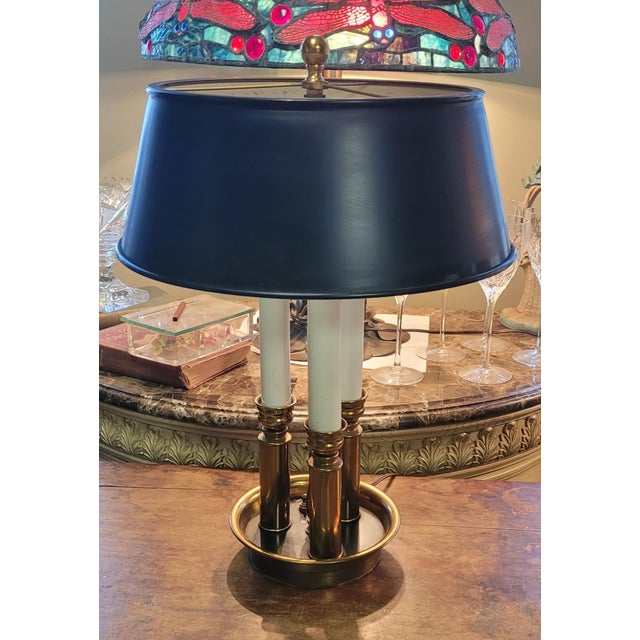 Fine 1950s three candle Bouillotte French style table lamp. Features all brass construction with a black metal shade....