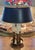 Fine 1950s three candle Bouillotte French style table lamp. Features all brass construction with a black metal shade....
