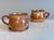 Two handcrafted ceramic mugs by Helma Klett, each with a workshop signature on the underside. Different designs in warm...