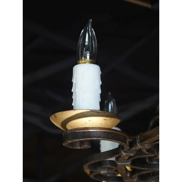 This attractive French iron chandelier is composed of 8 raised S-scroll motifs holding lights around its perimeter. Its...