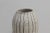 The sinuous lines of this vase are highlighted by the black vertical lines. It was made on the potter's wheel with...