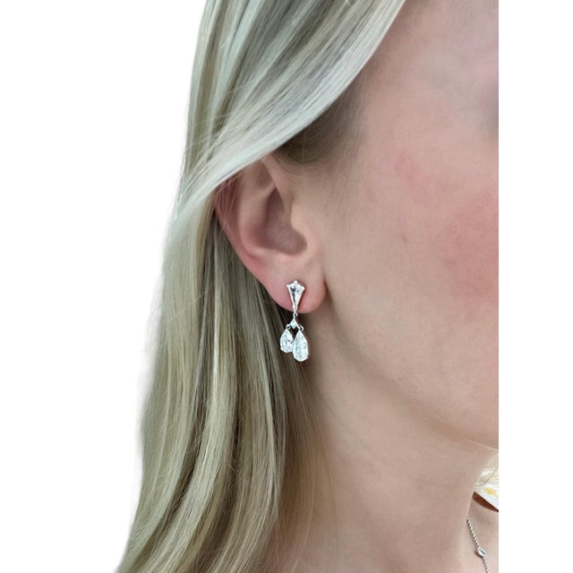 These elegant earrings are comprised of four kite shaped diamonds suspending four pear shaped diamond drops for a total...