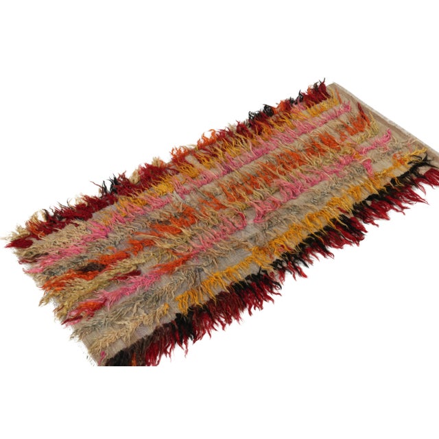 Hand-knotted in wool circa 1950-1960, this 3x6 vintage runner enjoys a delicious high pile in bold red, black, mango...