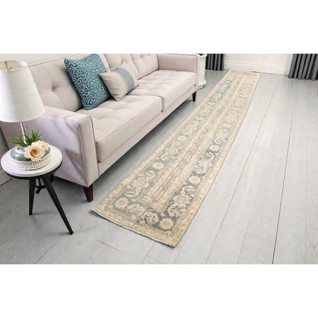 This is a vintage Turkish Oushak rug from the Mid 20th Century. The piece was hand-knotted.