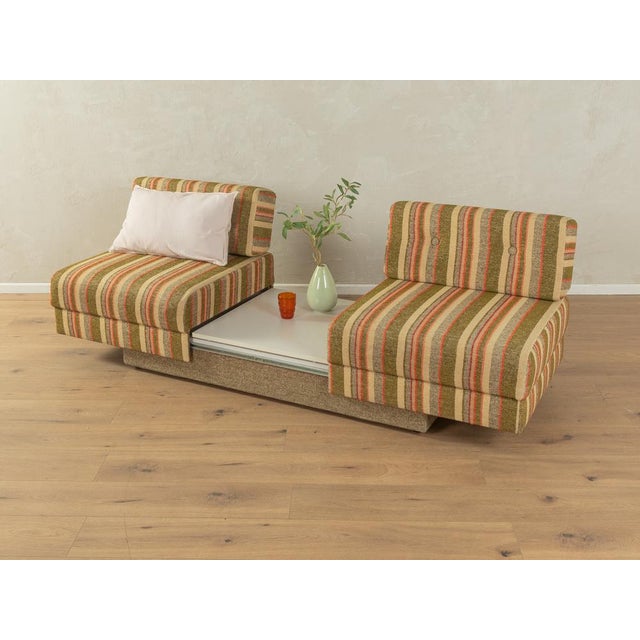 Super cool convertible sofa from the 1970s with colorful original upholstery in shades of green, beige, brown, and orange,...