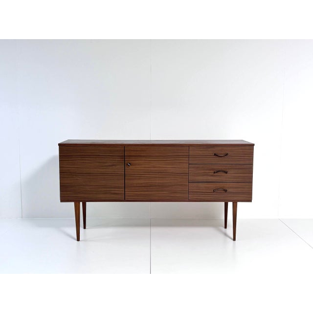 Elegant vintage sideboard in classic mid-century style, dating from the early 1970s. This piece of furniture impresses...