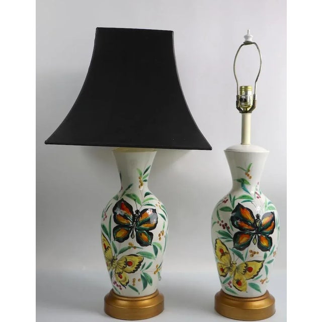 Pair of porcelain table lamps having white bodies with hand painted butterflies, and foliate decorations. Classic late...