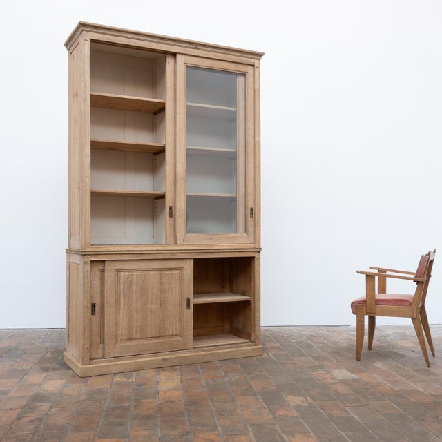 This large antique bookcase dates from the early 20th century. Made primarily of oak, it consists of two superimposed...