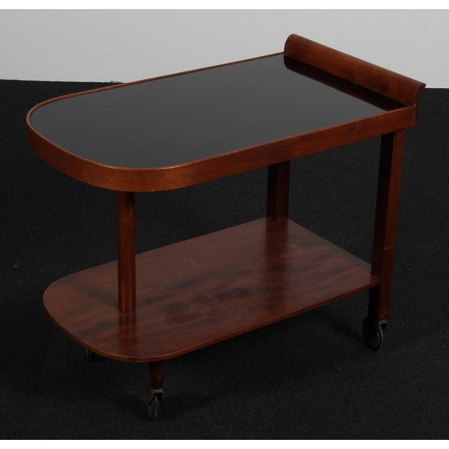 Art Deco tray table in mahogany. Table top with glass. Mounted on brass wheels. Made in Denmark in the 1930s