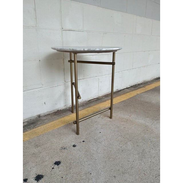Stylish Caracole Concentric Side Table. Round marble top with white/gray colors. Antiqued brass metal legs. Original...