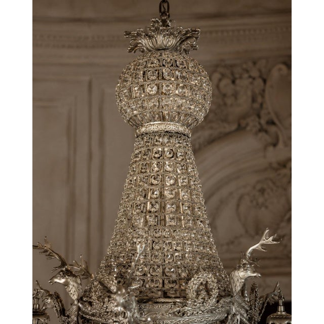 This striking circa 1980 French Louis XVI–style chandelier combines sculptural bronze craftsmanship with an unusual deer-...