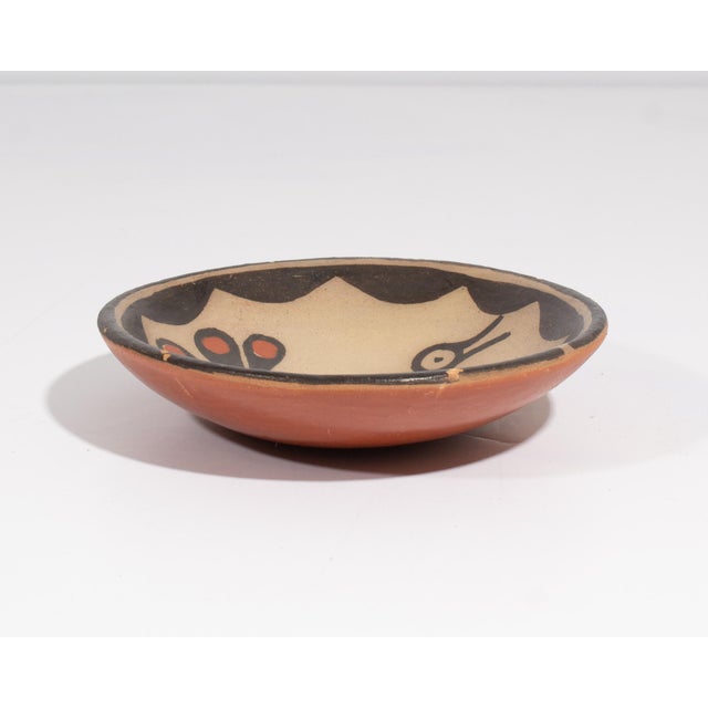 A pottery bowl by the Santo Domingo potter Hilda Coriz. Signed to the underside, this shallow bowl has a stylized bird...