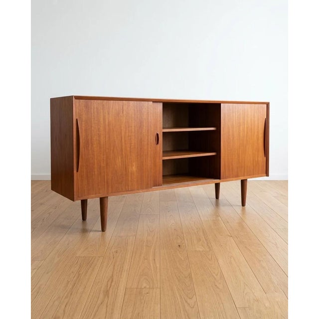 Danish teak sideboard from the 1950s, 180 cm. Three sliding doors with handles carved from solid wood, a typical and...