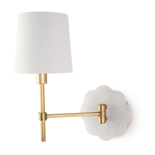 Mia swing arm sconce combines alabaster and natural brass for a femininely sophisticated light. The scalloped edge of the...
