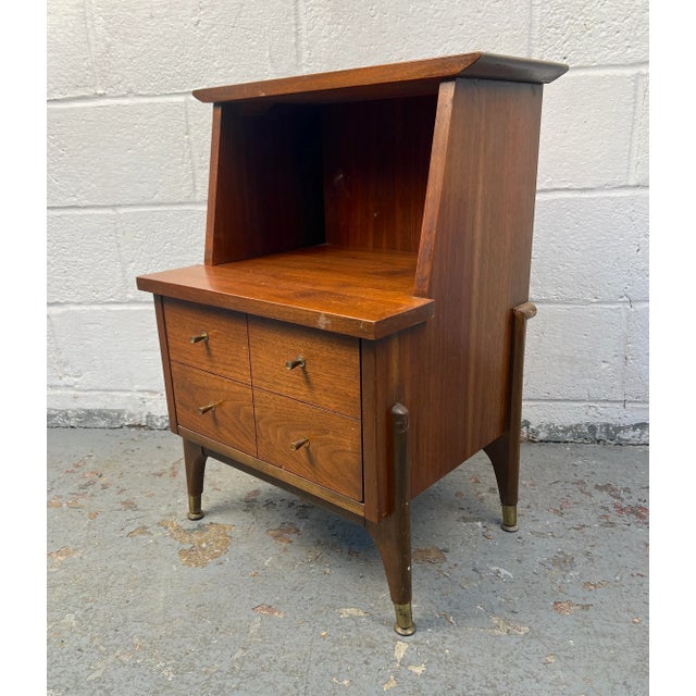 Charming mid-century nightstand featuring a two-tiered design that adds both height and functionality. Crafted with a...