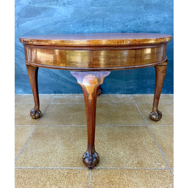 Elegant Spanish round side table dating to the mid-20th century. The table features a circular top above a shaped apron...