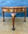Elegant Spanish round side table dating to the mid-20th century. The table features a circular top above a shaped apron...