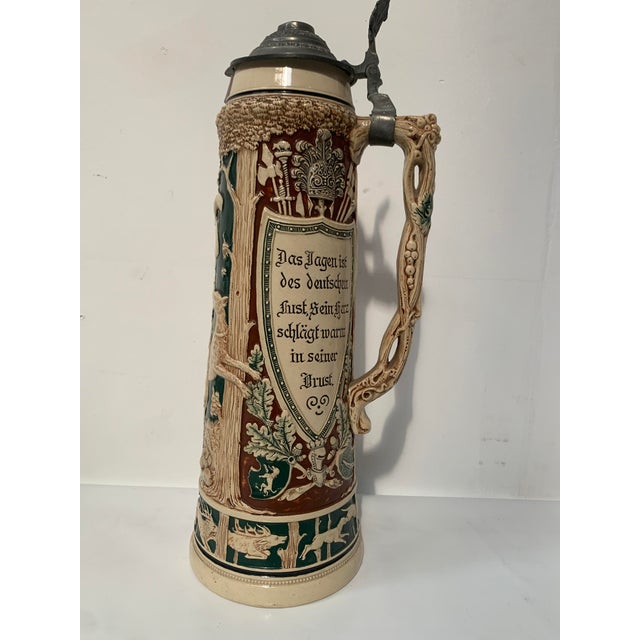 Large polychrome stoneware beer stein Decorated with Arminius in a hunting scene Small crack or firing flaw at the neck...