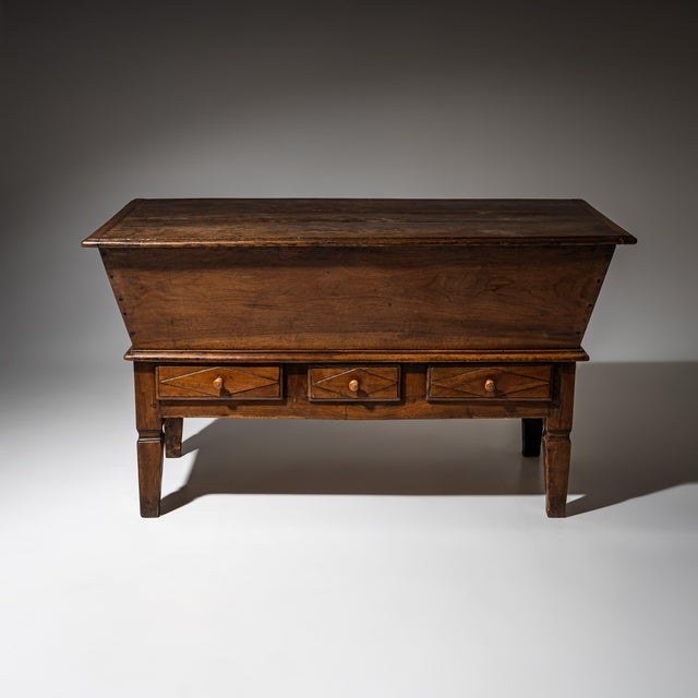 Large baker’s dough chest crafted from solid walnut, featuring a trapezoidal storage compartment concealed beneath a...