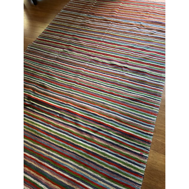 A vibrant and expressive piece, this vintage striped kilim brings together bold color and modern sensibility within a...