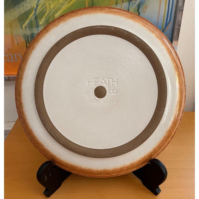 This is a vintage Heath Ceramics Sonoma chop plate, featuring a speckled off-white center framed by warm terracotta-brown...