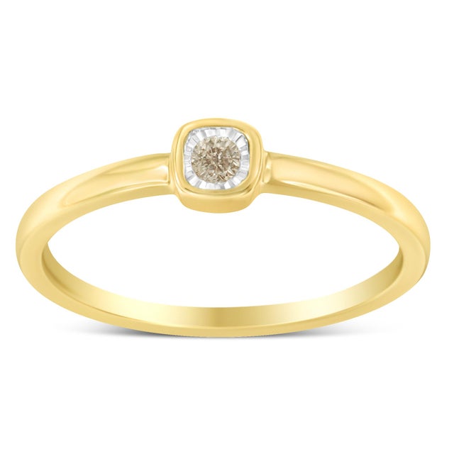 A diamond and yellow gold plated ring. The ring features a central round diamond miracle set in a 14 karat gold plated...