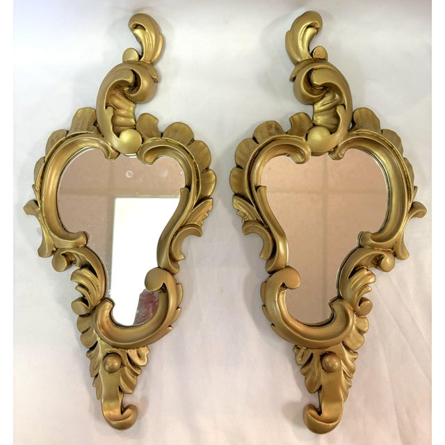 Sweet petite pair of scroll wall mirrors. They have an Art Nouveau/ Rococo cornucopia style with an antique gold painted...