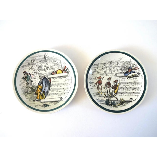 A pair of French opera plates, featuring "Robin des Bois" (Robinhood) and ""Le Pre aux Clercs" (The Clerks' Meadow). Hand-...