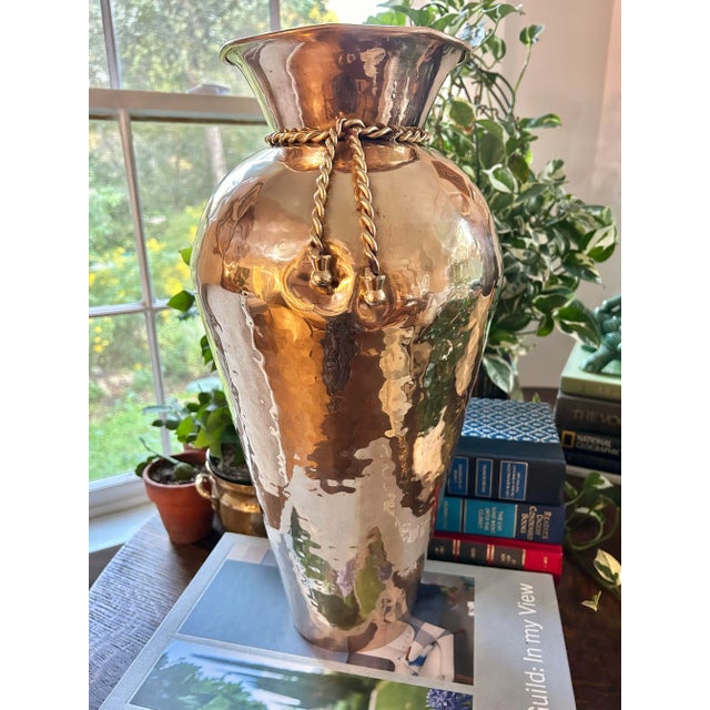 This hammered brass vase is the largest we’ve come across standing 16.5” tall. The vase has a “gathered” neck tied with a...