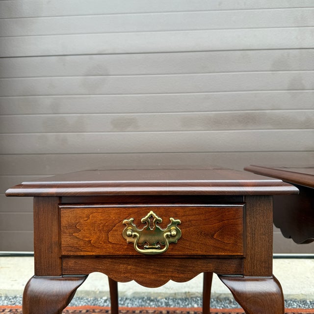 A pair of vintage Pennsylvania House Traditional Queen Anne solid cherry one drawer side tables in their auburn cherry...