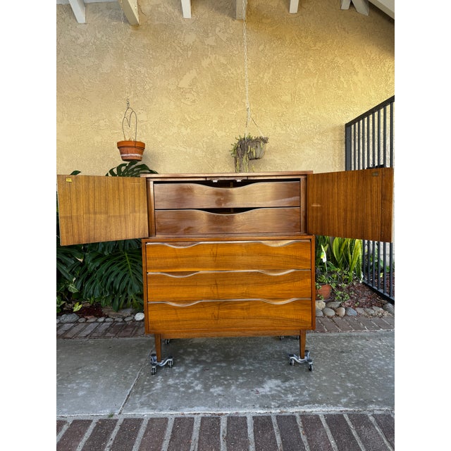 Beautiful MCM Walnut Vintage High Boy Dresser from American of Martinsville. Top front doors open to two drawers, atop...