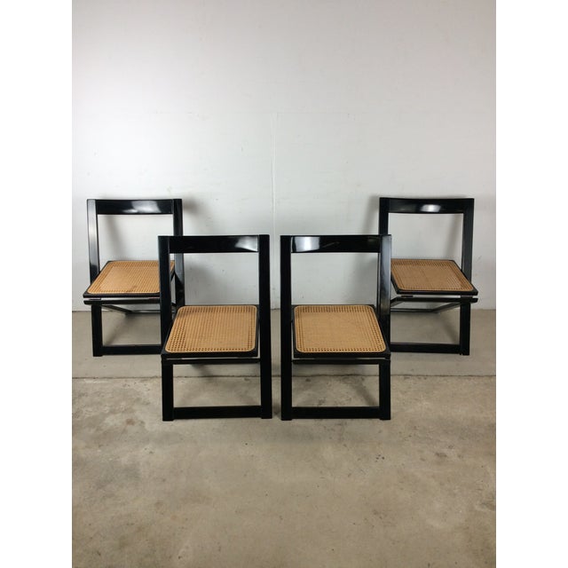 This set of four mid century folding chairs features hardwood construction, original black lacquer finish, and beautiful...