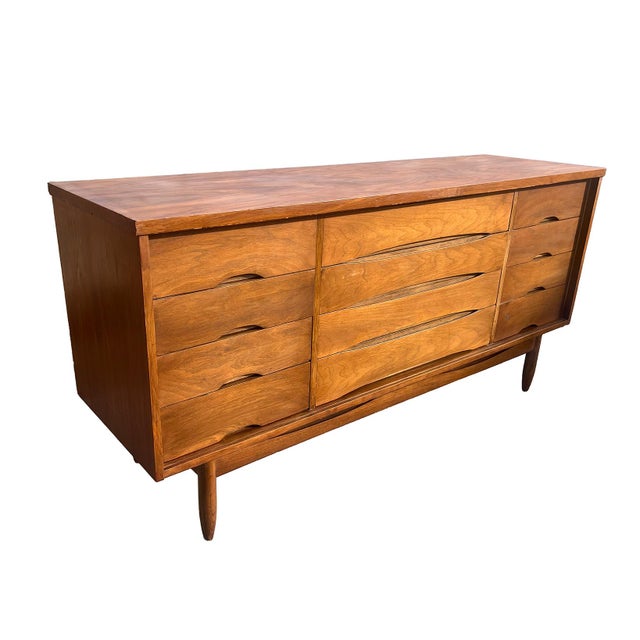 This Walnut lowboy has sculptural cut away drawers with a lower apron that echos the arched shapes of the drawers....