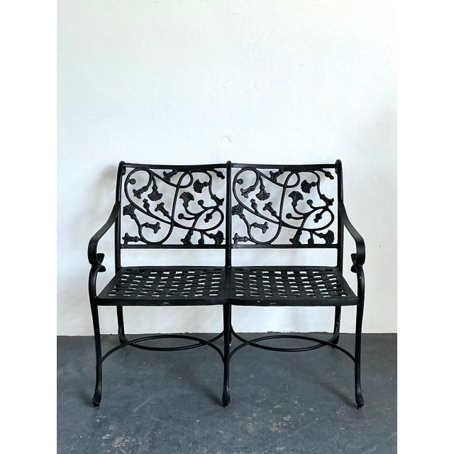 Evoke the charm of a sun-drenched European estate with this striking vintage wrought iron bench. Defined by its elaborate...