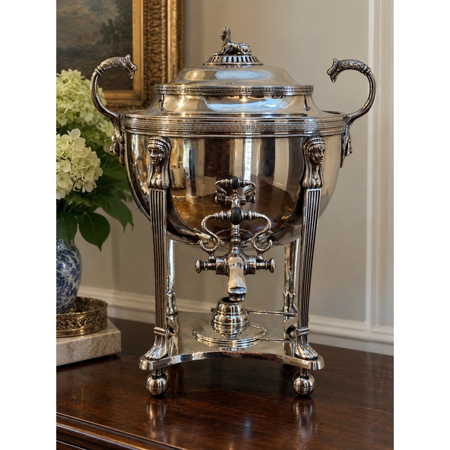 An elaborate antique Egyptian Revival silver-plated hot-water urn featuring a sculptural sphinx finial, Egyptian figural...