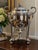 An elaborate antique Egyptian Revival silver-plated hot-water urn featuring a sculptural sphinx finial, Egyptian figural...