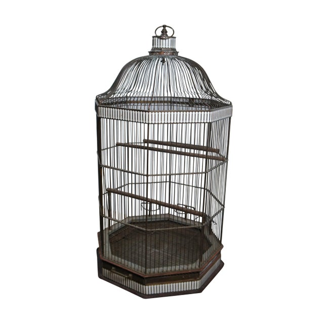 An impressive rare and monumental antique hanging brass bird cage. Octagonal form with dome top, three wooden perches (two...
