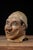 Large hand-painted papier-mâché carnival or funhouse character mask depicting a grinning male figure with dramatically...
