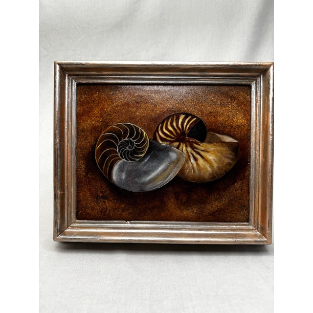 This silver finish framed vintage original oil painting features two beautifully rendered nautilus shells arranged in a...