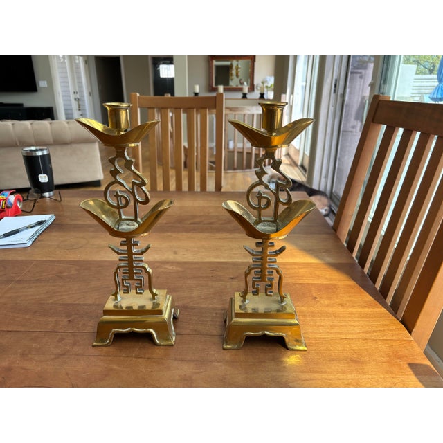 Pair of vintage solid brass candleholders featuring an elegant Asian-inspired design with geometric and sculptural...