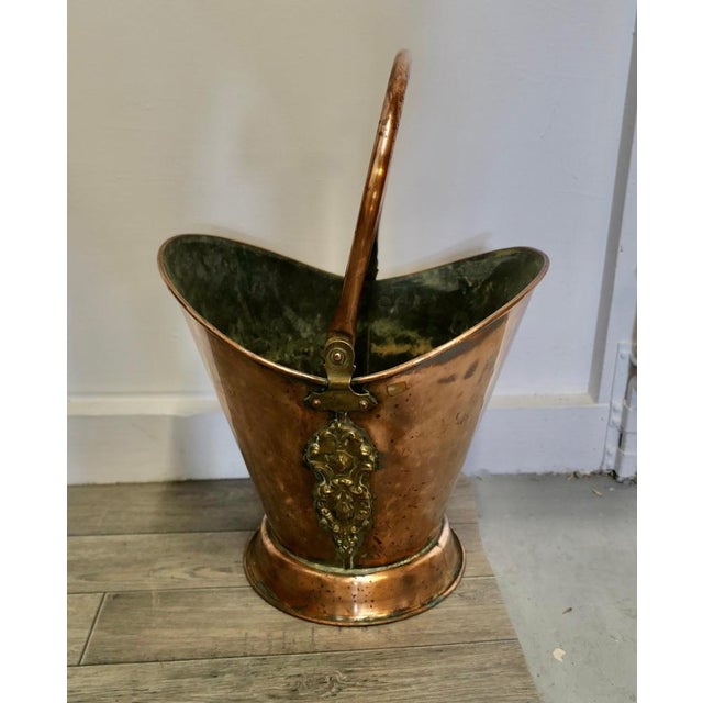An Art Nouveau Embossed copper helmet coal scuttle. This bucket is a very attractive Oval shape, it is made in beaten...