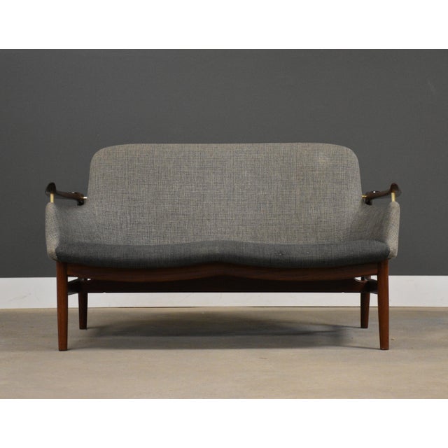 A mid century modern original solid teak two seater grey NV-53 sofa settee designed by Finn Juhl and expertly executed for...