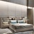 A modern Italian-style upholstered king bed designed with a dramatic extended headboard, integrated display shelving, and...