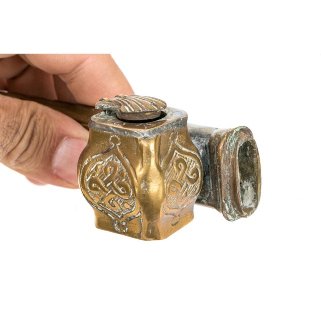 A beautifully detailed 19th century Persian brass scribe’s Qalamdan: a bombe shaped inkwell with a shell-shaped lid cover,...