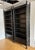 Stunning pair of vintage black faux bamboo etagere bookcases. Monumental Chinoiserie bookcase with one drawer at the base....