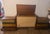 A striking matching pair of Hollywood Regency style trompe l'oeil multi-literary leatherette chest tables. Constructed...