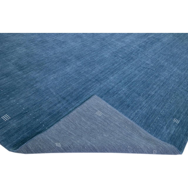 Beautiful modern Gabbeh-style hand-woven wool rug with a navy blue color field and gorgeous white minimalist design. This...