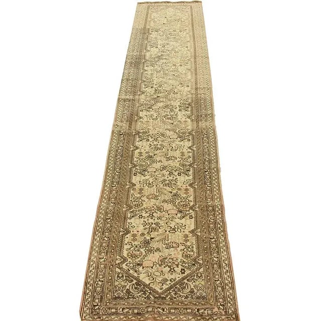 Handwoven old Persian Tafresh rug featuring an all over stylized floral design on an ivory colored field and red border...