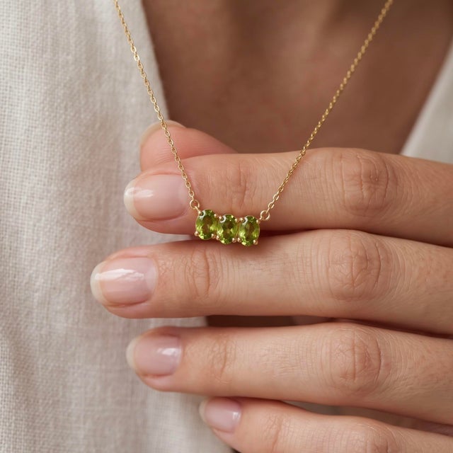 Infuse fresh, vibrant energy into your style with this striking three-stone pendant necklace, featuring two vivid olive-...