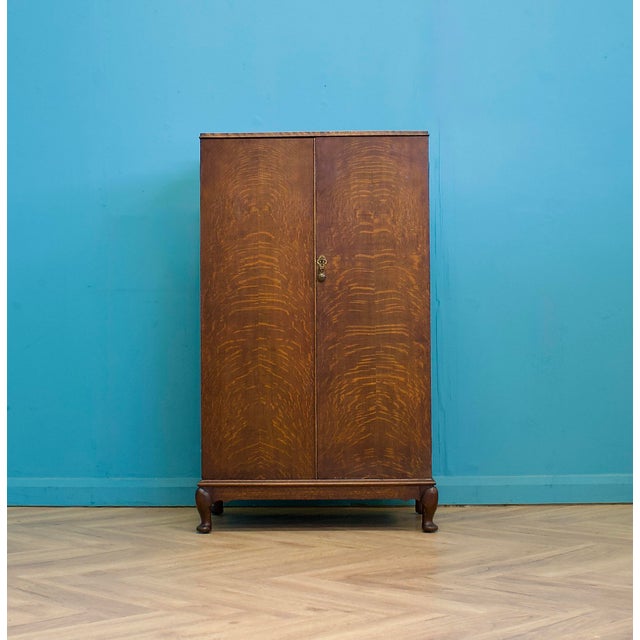 A tiger oak linen press cabinet dating to around 1930, featuring beautifully figured quarter-sawn oak veneers with bold...